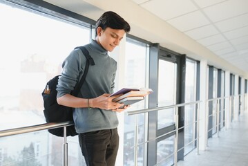 Portrait of indian college boy holding books.