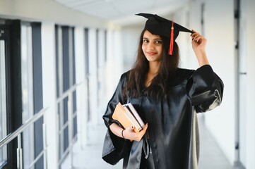 Young Asian Indian female graduate wearing robe. Achievement in life.Learning with confidence