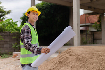 engineer concept The constructing manipulator who wears a hard yellow hat, dark-toned plaid blouse...