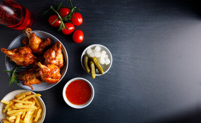 wood smoked chicken. Homemade wood smoked chicken legs with french fries and chili sauce on the side. Top view, on a white marble table top.