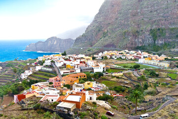 Agulo village, La Gomera, Canary Islands, in winter: colorful houses and terrace fields above the deep blue atlantic ocean.