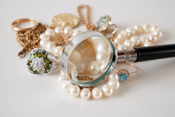 many golden and silver jewelry, pearls and money on white bakground, pawnshop concept, jewelry shop concept
