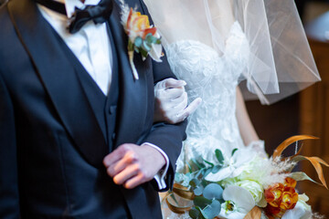 腕を組んで新婦の前に立つ新郎新婦