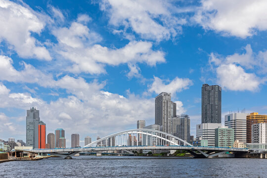Japan, Kanto Region, Tokyo, Clouds over waterfront skyscrapers with Tsukiji Great Bridge in foreground