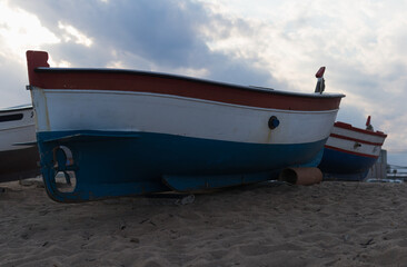 Image of some boats that are on a fisherman's beach with the sky in the background
