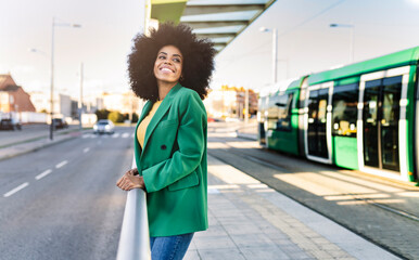 Smiling commuter standing at tram station