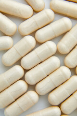 Fototapeta na wymiar Flat lay macro White beige capsule pills, tablets, top view, close up texture background pharmaceutical industry concept, copy space.