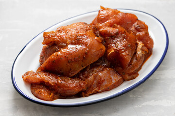 raw meat with marinate on big white dish on ceramic