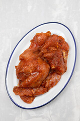 raw meat with marinate on big white dish on ceramic