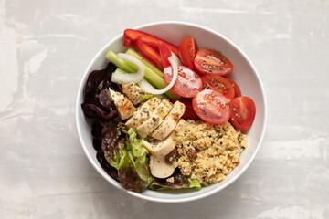 grilled chicken with salad, tabbouleh and fresh vegetables in the bowl