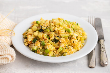 scrambled egg with zucchini on white small plate