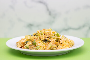 scrambled egg with zucchini on white small plate