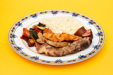 grilled meat with vegetables and rice on the plate