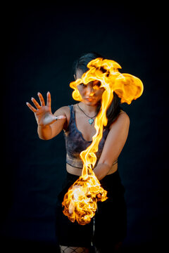 Performer playing with fire against black background