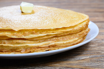 Stack of pancakes with butter on wooden table Close-up
