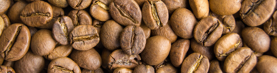 roasted coffee beans close-up. invigorating drink. power engineering specialist. Horizontal image. Banner for insertion into site.