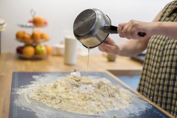 Grandmother prepares dough for croissants, close-up on hands