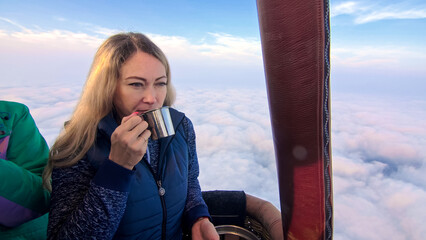 Woman eat sandwich and drinks tea and coffee in flight. Adventure on hot air balloon. Burner...