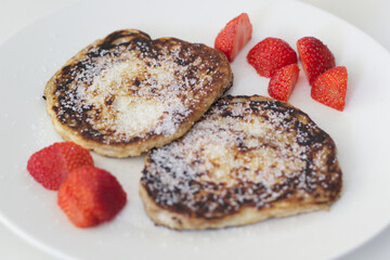 French toast pancakes with sugar and strawberries