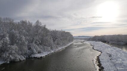 Mountain river in winter. On the shore of which are beautiful trees