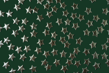 Silver stars lie on a dark green background.