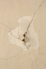 A close-up of the damaged plasterwork on a wall. This plasterwork definitely needs to be repaired.
