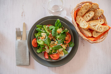 top view green salad with vegetables and parmesan shavings in a plate on a table