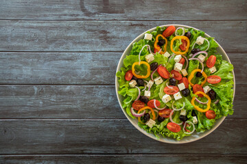 top view green salad with vegetables and feta in a plate on a table