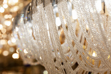 Expensive elegant crystal chandeliers in the salon. Big choice. Interior design. Close-up.