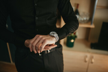 Businessman checking the time on his wrist watch.