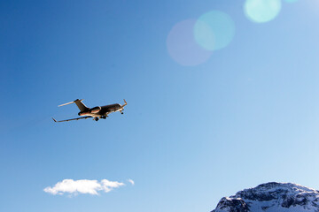Fototapeta na wymiar A private jet flying up in the blue sky in Engadine St Moritz