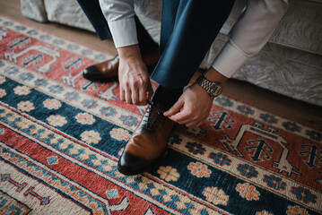 The man wears shoes. Tie the laces on the shoes. Men's style. Professions. To prepare for work, to the meeting.