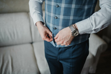 Young handsome man in classic suit. Young businessman puts on suit and prepares for a meeting.