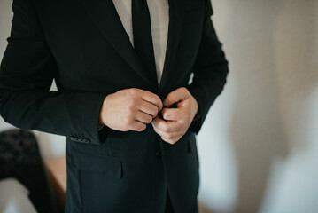 Young handsome man in classic suit. Young businessman puts on suit and prepares for a meeting.