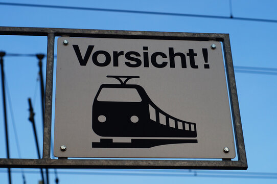 A sign above a pedestrian crossing warns of approaching trains.