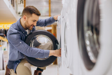 Couple choosing wasing machine at electronics store