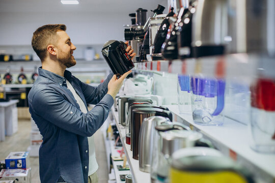 Man choosing electric kettle at store