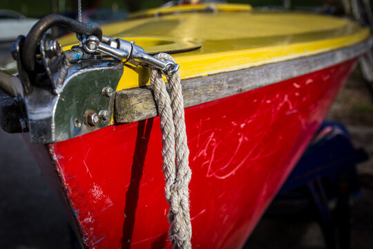 Nahaufnahme eines Segelboots an Land mit gelbem Deck und rotem Rumpf