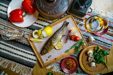 Baked fish seabass with fish spices, wine and salad. Seafood in restaurant. Top view. Healthy eating