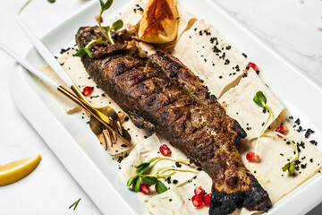 Baked trout fish with salt, lemon. Grilled trout. Fish dish fried fish fillet with vegetables. Ketogenic, keto or paleo diet lunch, Healthy food trend. Top view