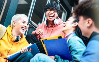 Fototapeta Multiracial students having fun together sitting outside school - Happy best friends enjoying time in college campus - Youth lifestyle and scholarship concept obraz