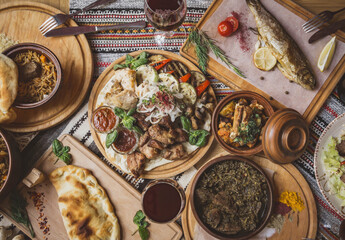 A lot of food on the wooden table. Georgian cuisine. Top view. Flat lay . Khinkali and Georgian dishes