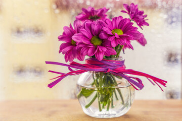 Bukiecik różowych kwiatów w małym szklanym wazonie. - obrazy, fototapety, plakaty
