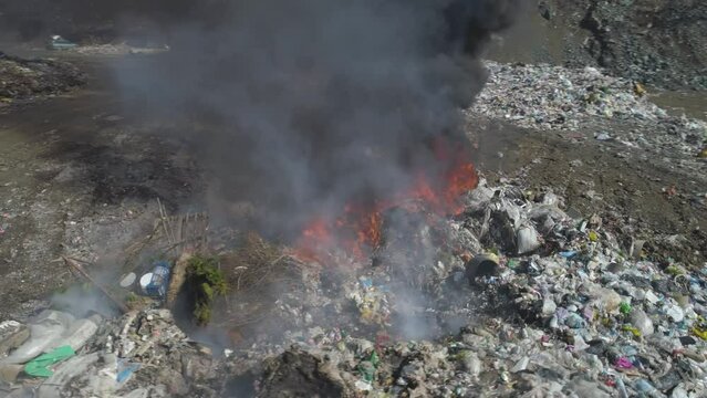 Aerial drone view of large garbage landfill, burning trash with loth of polluting smoke. 