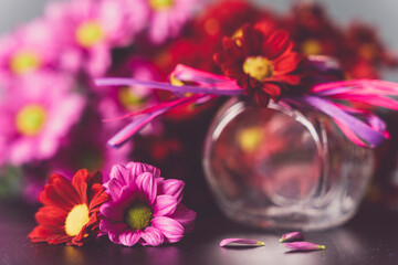Bukiecik różowych kwiatów w małym szklanym wazonie.