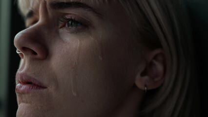 Close Up of a Beautiful Blonde and Young Caucasian Woman Feeling Depressed and Crying with Sad...