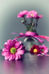 Bukiecik różowych kwiatów w małym szklanym wazonie.