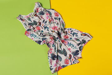 female colored summer dress or jumpsuit on green and yellow background, summer holiday concept