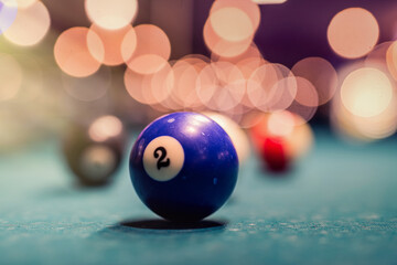 balls for billiards stand in a triangle on a green table before the first serving of the ball.