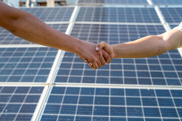 shaking hands against solar panel  after the conclusion of the agreement in the renewable energy